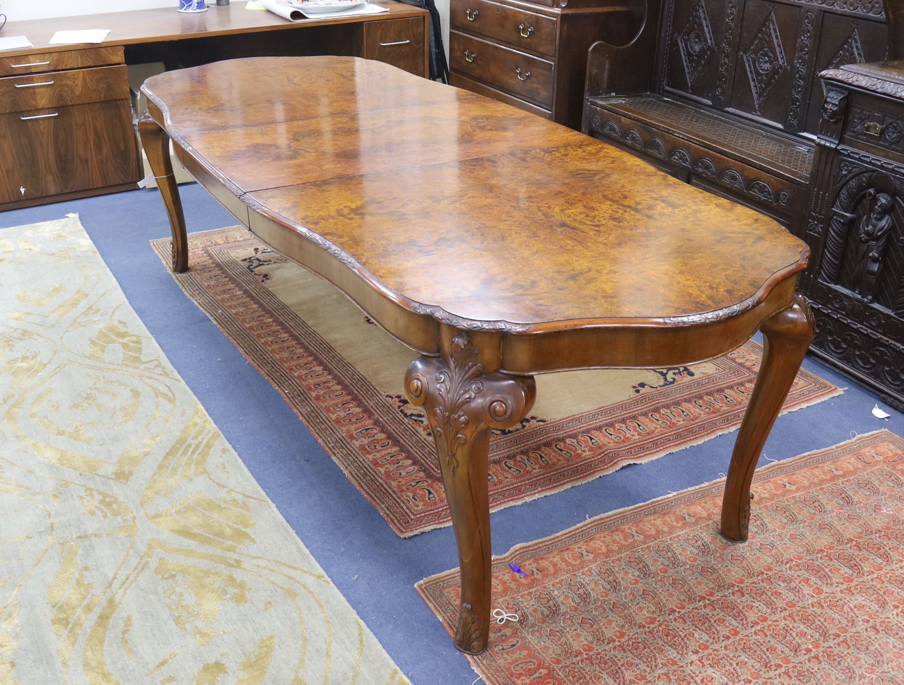 A Queen Anne revival burr walnut shaped oval extending dining table, 272cm extended, one spare leaf, width 106cm, height 75cm